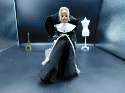 7 INCH 1950S HARD PLASTIC NUN IN BLACK ROBE, WHITE COLLAR, AND HABIT